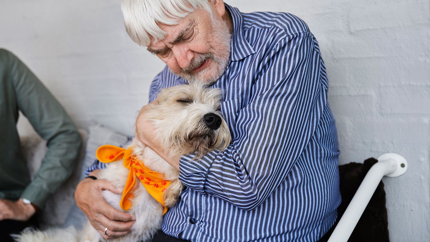 En beboer omfavner besøgshunden Elvis.